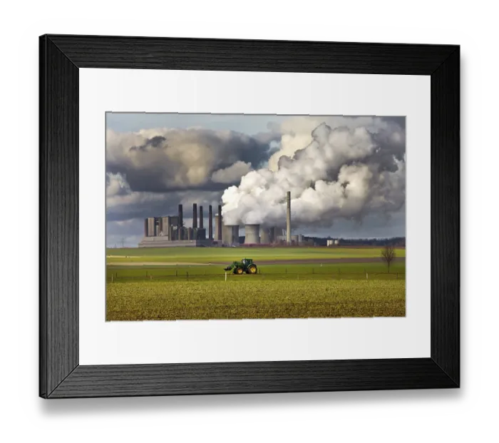 Framed Print : Tractor on a field in front of the steaming lignite-fired power station Frimmersdorf