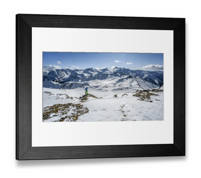 Framed Print : Man, ski tourer looks over snow-covered mountain ranges