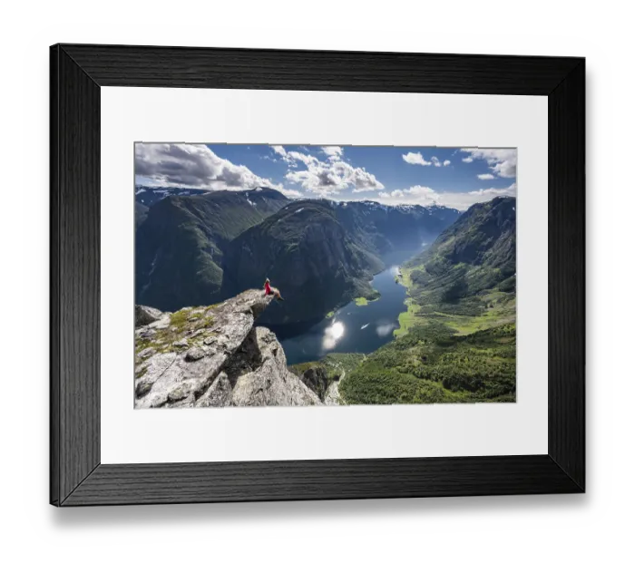 Framed Print : Hiker sitting on rock, view from the top of Breiskrednosi