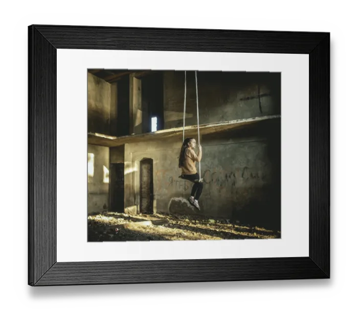 Framed Print : Girl rocking on a swing in a destroyed building on the seafront in Okhamchira
