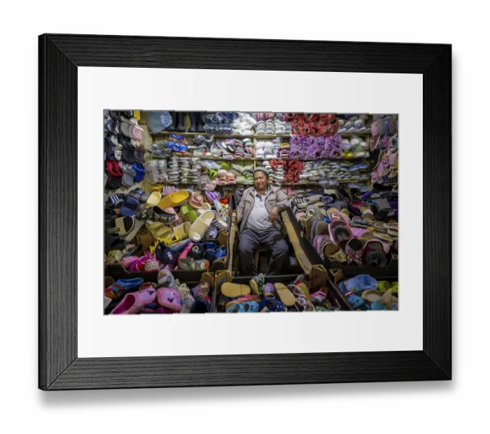 Framed Print : Vendor of shoes in his stall, very many shoes