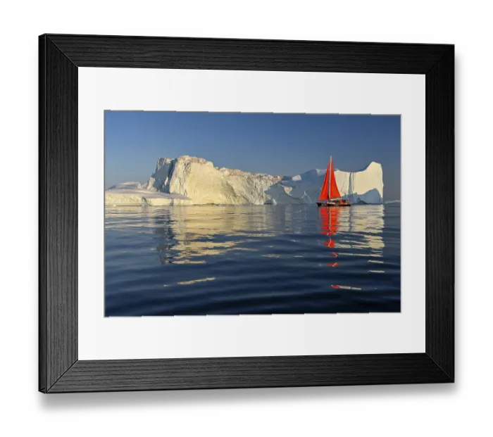 Framed Print : Red sailing boat in front of icebergs