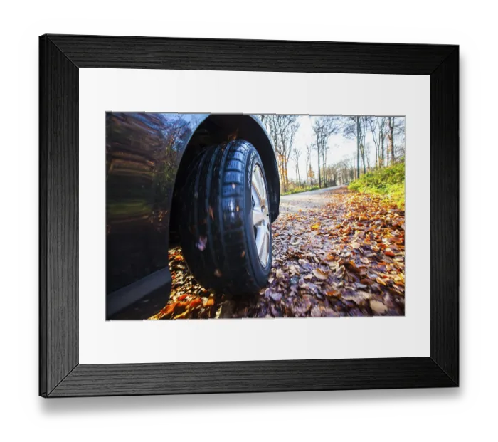 Framed Print : Car driving on a street covered with leaves