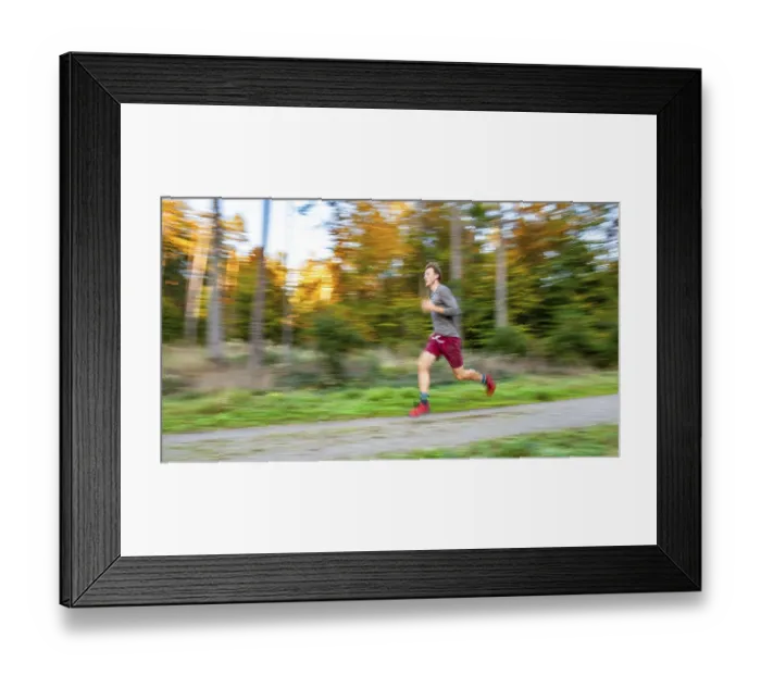Framed Print : Young man jogging in the autumnal forest