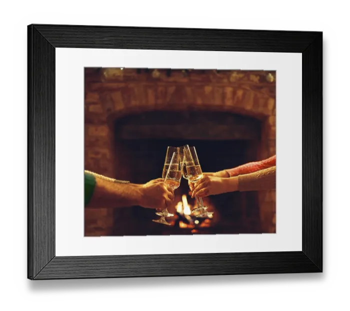 Framed Print : People clinking champagne glasses while gathering around fireplace in country house