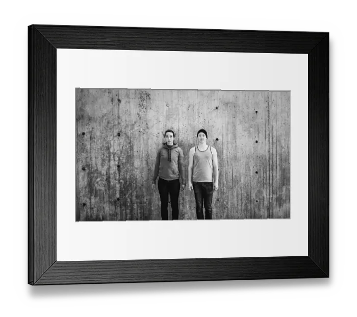Framed Print : Young woman and man standing in front of concrete wall Framed Print : Young woman and man standing in front of concrete wall