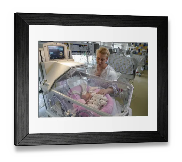 Framed Print : Mother of twins with one of her newborns in an incubator