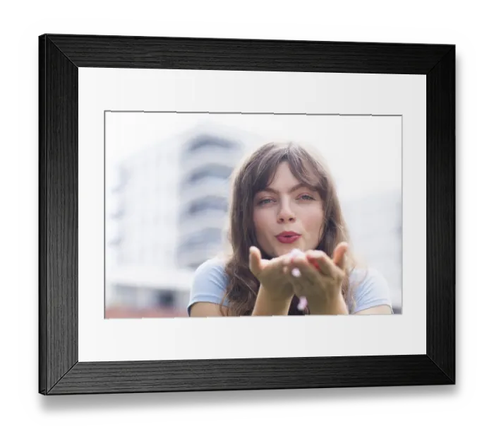 Framed Print : Young woman with long hair blowing into her hands