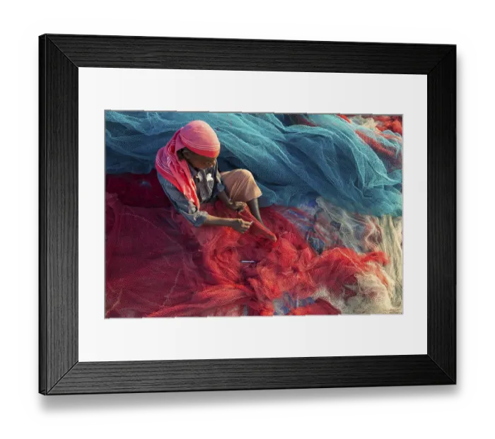 Framed Print : Fisherman repairing fishing nets