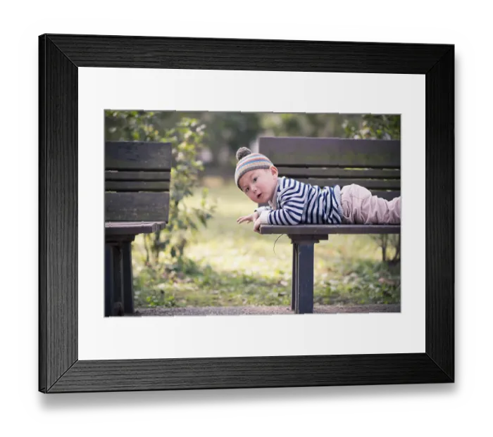 Framed Print : Child lying on a bench in the park