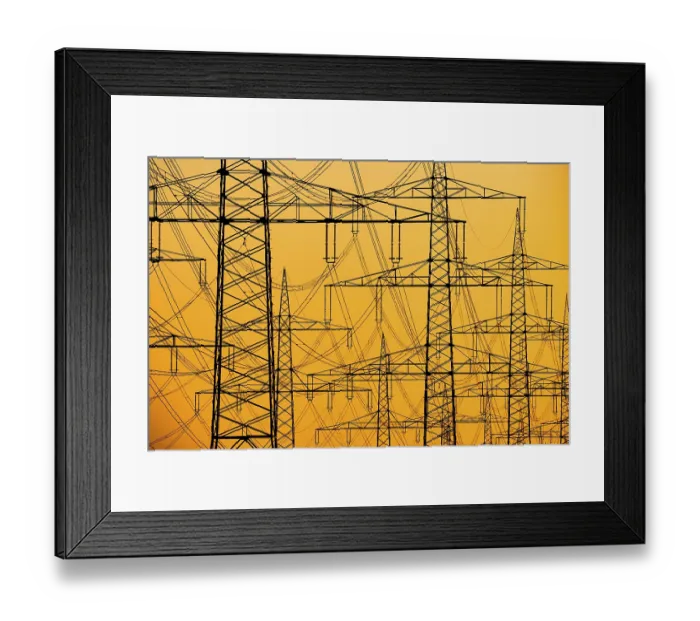 Framed Print : Electricity pylons of a power line at sunset