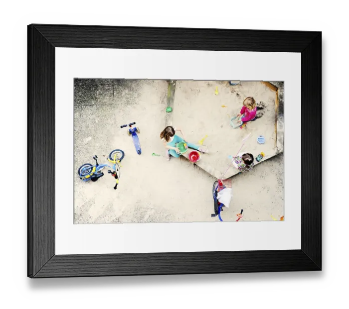 Framed Print : Children playing in the sandbox of a backyard