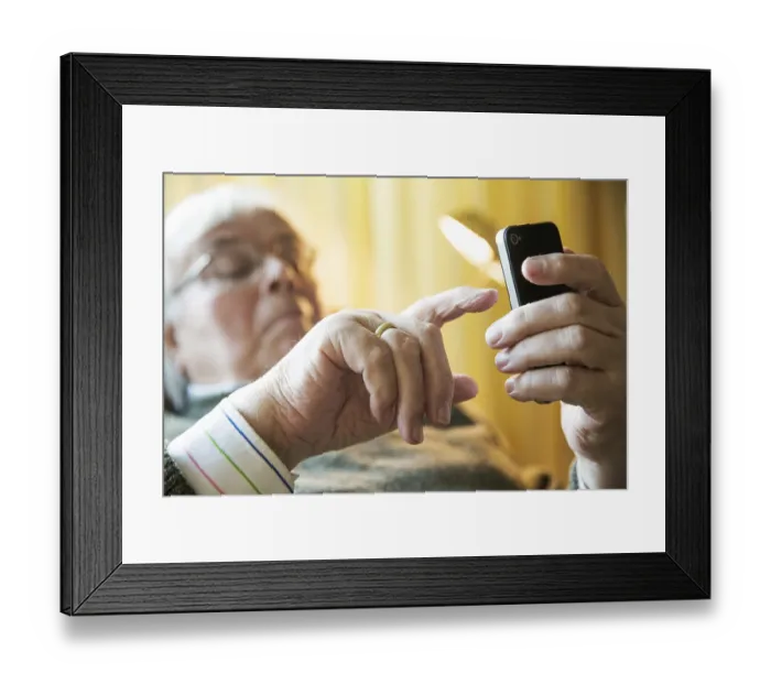 Framed Print : Elderly man working on his smartphone