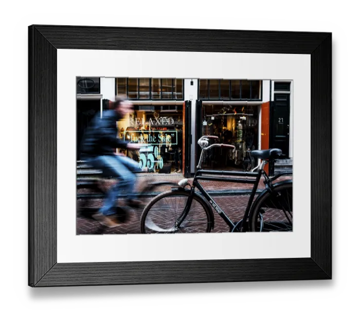Framed Print : Cyclist rides through shopping street Framed Print : Cyclist rides through shopping street