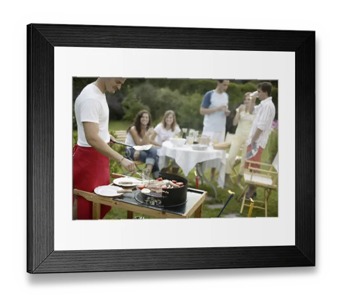 Framed Print : Group of young people having a barbecue in the garden