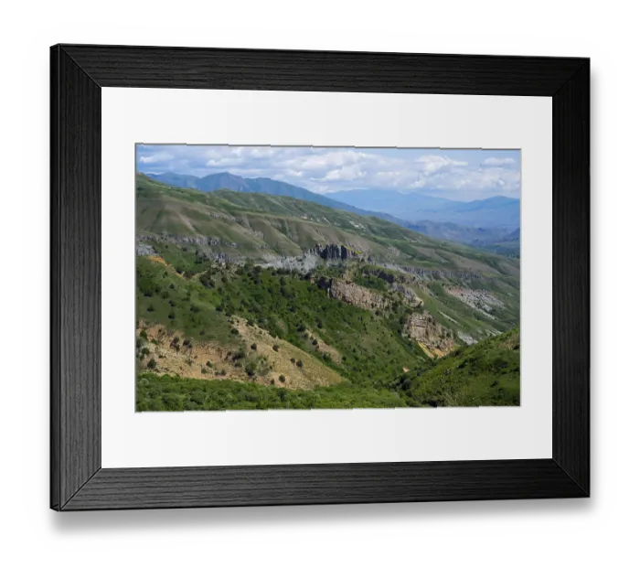 Framed Print : Rocks and green hills stretch under a blue sky Framed Print : Rocks and green hills stretch under a blue sky