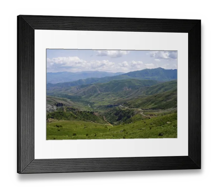Framed Print : Rolling hills and mountains around a wide valley with green vegetation