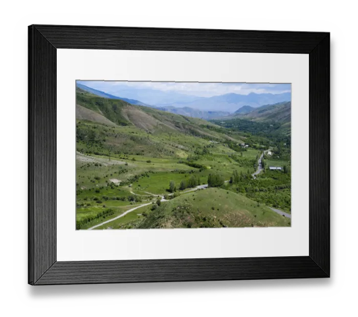 Framed Print : Green fields and rolling hills with roads leading through the area