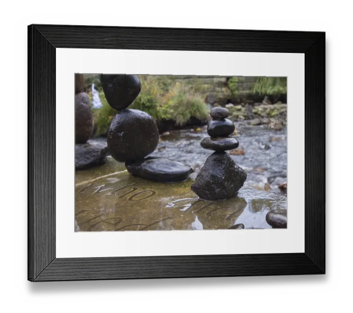 Framed Print : Balanced stones stack next to a stream