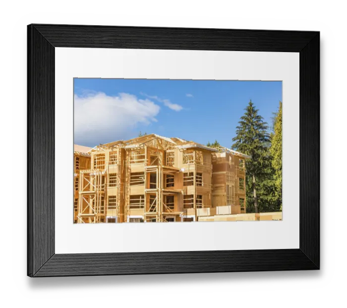 Framed Print : New apartment building under construction with two trunks of timber stored on side Framed Print : New apartment building under construction with two trunks of timber stored on side