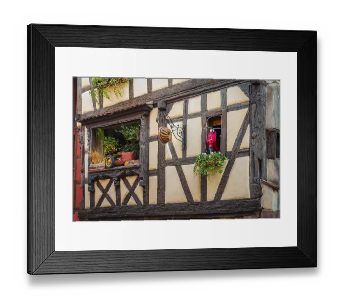 Framed Print : Timber-frame house decorated with vehicles in the historic old town of Riquewihr