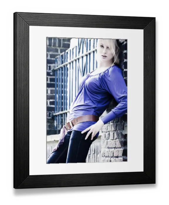 Framed Print : Young blond girl outside on a street posing against the wall