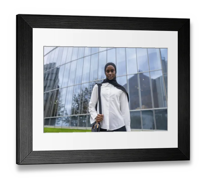 Framed Print : Confident young black woman wearing a hijab and carrying a shoulder bag