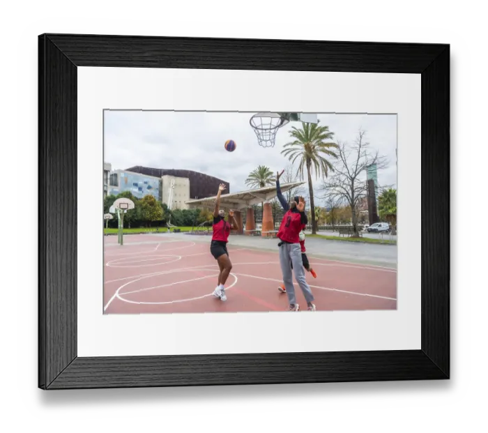 Framed Print : Two diverse women in red jerseys actively playing basketball on an outdoor court Framed Print : Two diverse women in red jerseys actively playing basketball on an outdoor court