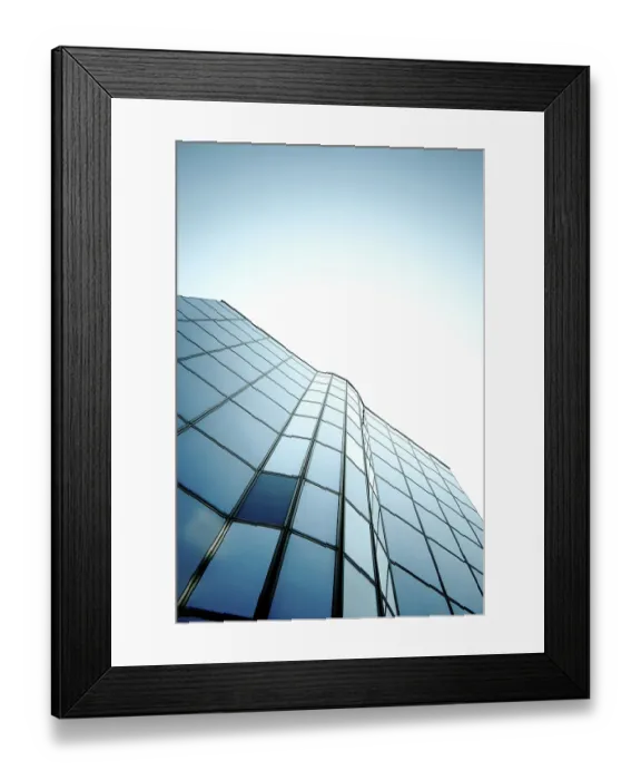 Framed Print : Modern skyscraper with glass windows reflecting a gradient blue sky in a sleek vertical design