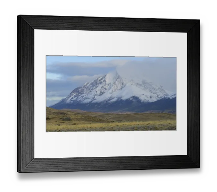 Framed Print : Snowy mountain peaks partially covered by clouds in a vast landscape