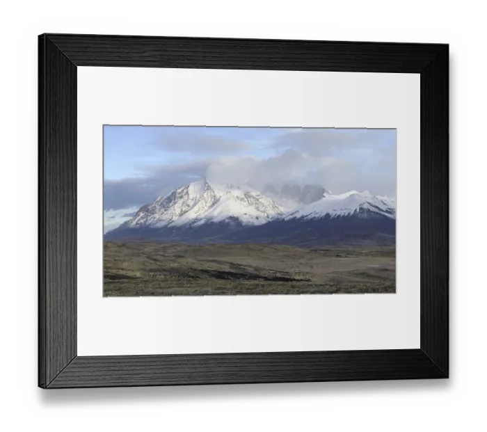 Framed Print : Expansive view of snowy mountains and open fields under a cloudy sky Framed Print : Expansive view of snowy mountains and open fields under a cloudy sky