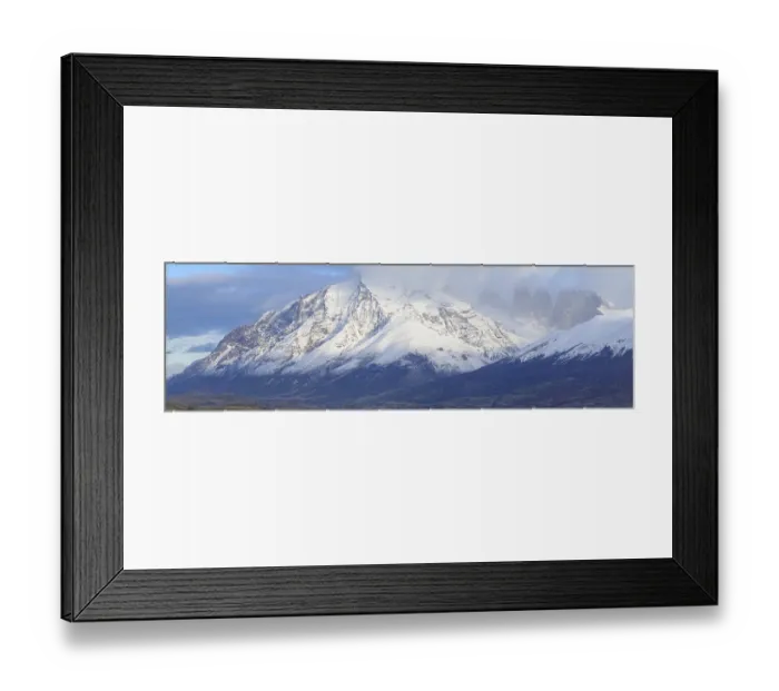 Framed Print : Panoramic view of massive snowy mountains partially covered by clouds