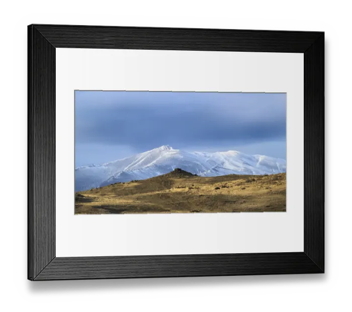 Framed Print : Solitary snow-covered mountains with a tranquil sky bathed in golden light