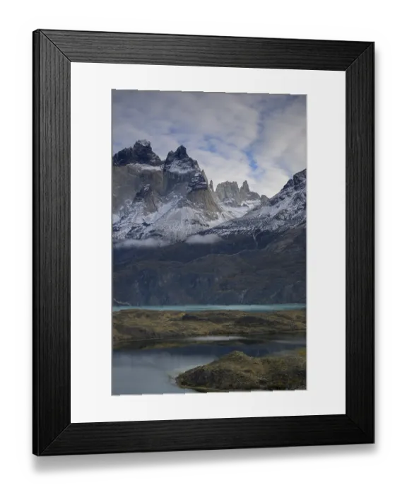Framed Print : Snowy mountains near a turquoise lake under a cloudy sky Framed Print : Snowy mountains near a turquoise lake under a cloudy sky