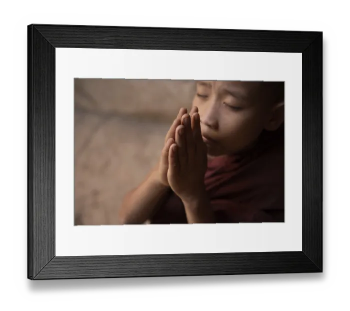 Framed Print : Young novice monk praying inside Buddhist temple Framed Print : Young novice monk praying inside Buddhist temple