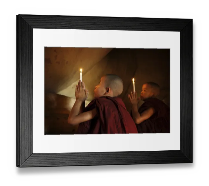 Framed Print : Little novice monks praying in front candlelight