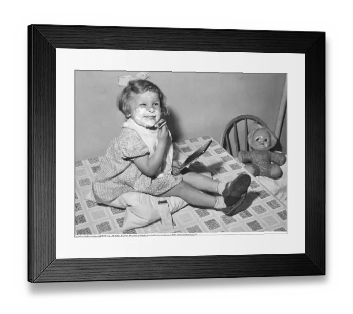 Framed Print : In the 1950s, a little girl with soap on her chin is captured in a playful moment Framed Print : In the 1950s, a little girl with soap on her chin is captured in a playful moment