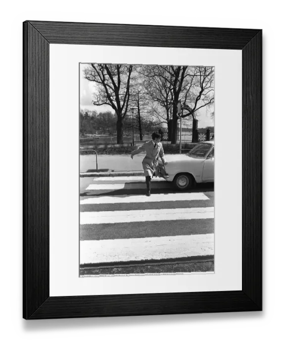 Framed Print : In the 1960s. A moment when a man walks on a pedestrian crossing but a car has not noticed him and keeps driving