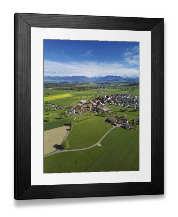 Framed Print : View of town with field of blooming rapeseed