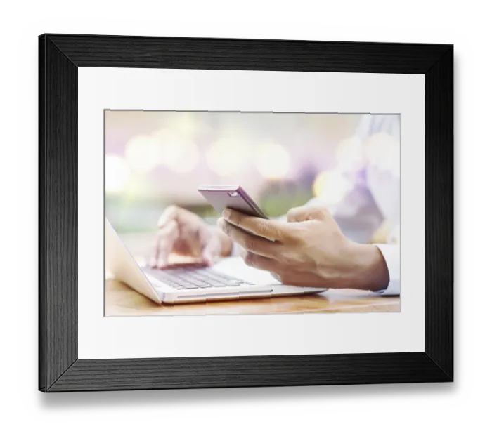 Framed Print : Asian Indian businessman using smartphone and laptop computer at outdoor cafeteria