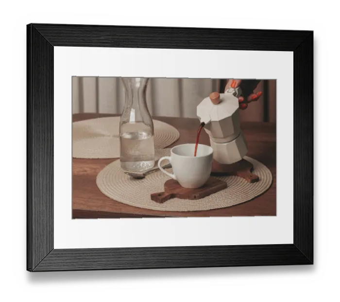 Framed Print : A hand pours freshly brewed coffee from a stovetop maker into a white cup Framed Print : A hand pours freshly brewed coffee from a stovetop maker into a white cup