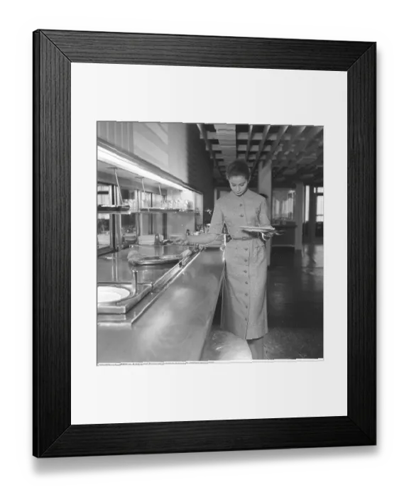 Framed Print : She dressed nicely 1956. The young model is helping herself to the food at the restaurant