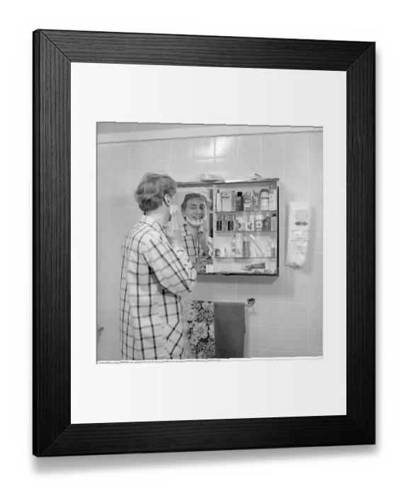 Framed Print : Preparing for a shave: A man stands in front of a bathroom mirror in his pyjamas