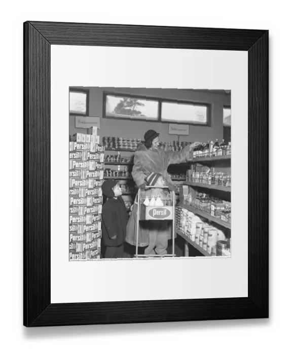 Framed Print : Shopping in the 1950s. A woman shops in a self service store