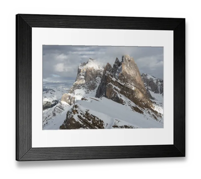 Framed Print : Snow-covered mountains rose majestically in the cloudy sky