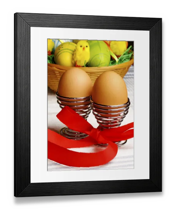 Framed Print : Brown eggs in metal holders with a red ribbon