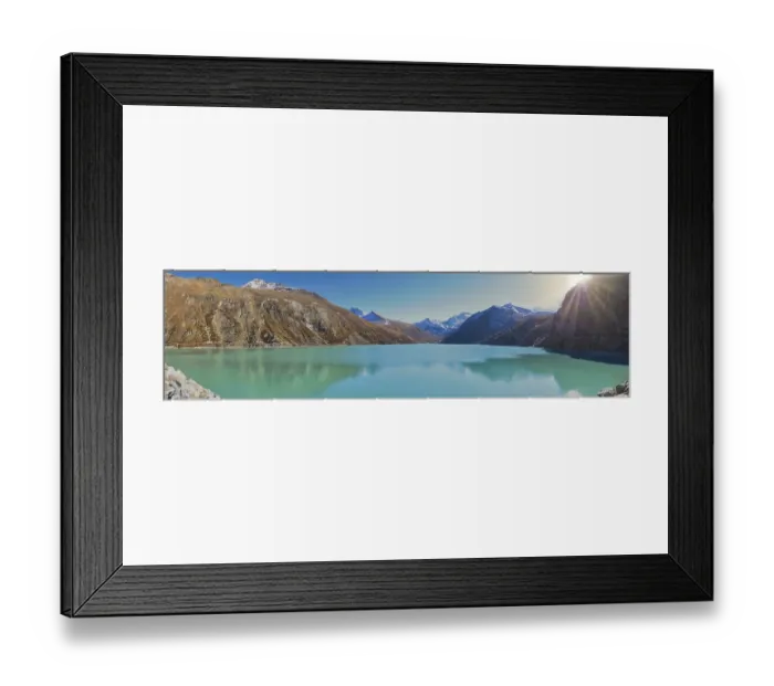Framed Print : Sunshine over a turquoise lake in the mountains with snow-capped peaks