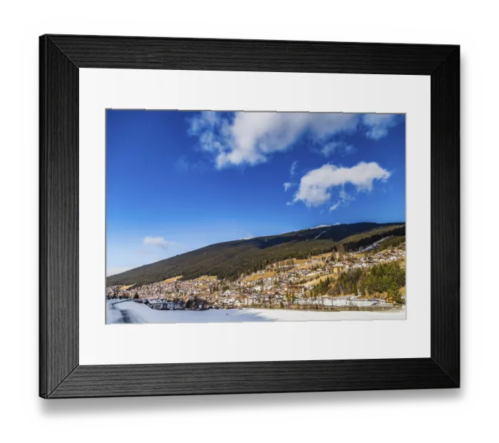 Framed Print : Snowy alpine village in Italy illuminated by sun with mountains in the background Framed Print : Snowy alpine village in Italy illuminated by sun with mountains in the background