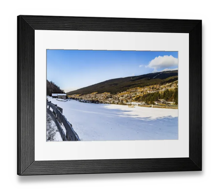 Framed Print : Snowy alpine village in Italy illuminated by sun with mountains in the background