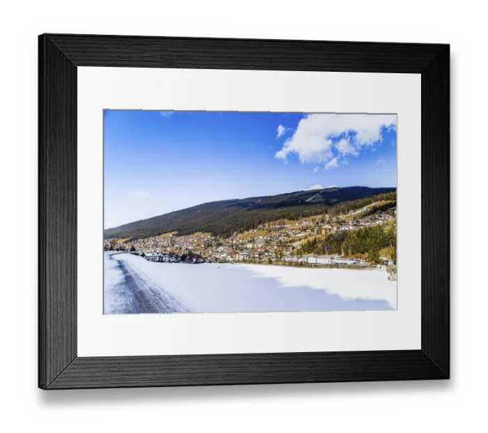 Framed Print : Snowy alpine village in Italy illuminated by sun with mountains in the background